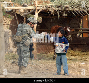 Ein US-Soldat aus 2. Platoon, Bravo Kompanie, 1. Bataillon, 30. Infanterie-Regiment, 2nd Brigade Combat Team interagiert 3. Infanterie-Division mit einem lokalen Kind während einer abgesessene Patrouille in Arab Jabour, Irak, 29. November 2007. Der Zug-Mission ist zu pflegen und schützen Sie die Umgebung.   SPC. Angelica Golindano Stockfoto