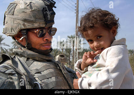 Ein Soldat der US-Armee von Delta Unternehmen 30. Infanterie-Regiment, 2nd Brigade Combat Team, 1. Bataillon, 3. US-Infanteriedivision hält ein irakische Kind in Al Buaytha, Irak, 17. November 2007.  SPC. Angelica Golindano Stockfoto