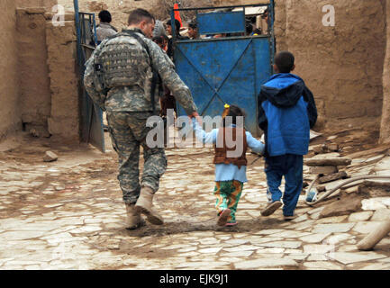 US Armee Captain Troy Thomas, aus Alpha-Truppe, 3. Infanterie-Division, 3. Bataillon, 1. Kavallerie-Regiment, 3. Heavy Brigade Combat Team hält Hände mit einem jungen irakischen Mädchen, als er zu seinem Humvee in einem Dorf außerhalb von Patrol Base Assassin, Irak, 10. Januar 2008 geht.  Sgt. Timothy Kingston Stockfoto