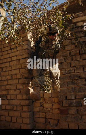 US Armee Sgt. Steven Saddler, von Baker Company, 3. US-Infanteriedivision, 1. Bataillon, 15. Infanterie-Regiment, 3. Heavy Brigade Combat Team klettert über eine Mauer während eines Suchvorgangs für Waffenlager mit betroffenen Bürger in Ja'ara, Irak, 17. Januar 2008.  Sgt. Timothy Kingston Stockfoto