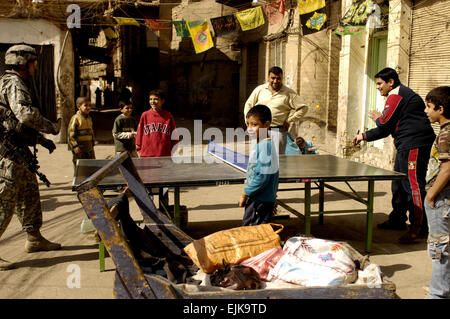 US Armee Sgt. Edward Watson, 3rd Platoon, Charlie Kompanie, 1. Bataillon, 504th Parachute Infantry Regiment, spielt Pingpong mit einem Teenager während einer Patrouille in Rusafa, Bagdad, Irak, 17. Februar 2008.  Staff Sgt Jason T. Bailey veröffentlicht Stockfoto