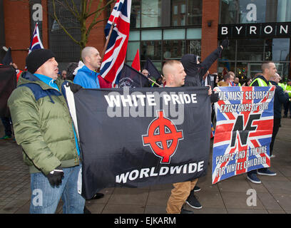 White Pride Worldwide Protest in Manchester, Großbritannien März 2015. Rechtsextreme Demonstranten mit Fahnen und Spruchbändern bei der Demo der Nationalen Front in Piccadilly. Die rechtsextreme Gruppe „White Pride“, die sich in Manchester versammelt hatte, um eine Demonstration zu inszenieren, wurde verhaftet, als etwa 50 Mitglieder der Gruppe Fahnen schwenkten und durch die Piccadilly Gardens marschierten. Antifaschistische Aktivisten veranstalteten eine Gegendemonstration und die Polizeilinie trennte die beiden Seiten. Die Polizei von Greater Manchester sagte, dass zwei Verhaftungen vorgenommen wurden, eine wegen eines Bruchs des Friedens. Der zweite wurde auch wegen einer öffentlichen Ordnungswidrigkeit festgehalten. Stockfoto