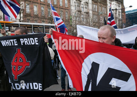 Rechtsextreme Demonstranten mit Fahnen und Spruchbändern bei der National Front und der White Pride Demo in Piccadilly. Manchester, Großbritannien, März 2015. Die rechtsextreme Gruppe „White Pride“, die sich in Manchester versammelt hatte, um eine Demonstration zu inszenieren, wurde verhaftet, als etwa 50 Mitglieder der Gruppe Fahnen schwenkten und durch die Piccadilly Gardens marschierten. Antifaschistische Aktivisten veranstalteten eine Gegendemonstration und die Polizeilinie trennte die beiden Seiten. Die Polizei von Greater Manchester sagte, dass zwei Verhaftungen vorgenommen wurden, eine wegen eines Bruchs des Friedens. Der zweite wurde auch wegen einer öffentlichen Ordnungswidrigkeit festgehalten. Stockfoto