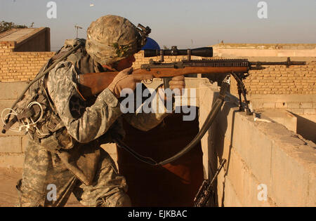 US Army Spc. Jason Pfau, ein Schütze aus Alpha-Truppe, 1. Staffel, 14. Kavallerie-Regiment, scannt die Dächer von seiner Overwatch Position während einer Kordon und Suche Mission in Bagdad, Irak, 8. Februar 2007. Die A-1/14. CAV führt Kordon und Suche Missionen mit 2. Bataillon, 1. Brigade, 6. irakische Nationalpolizei, um Sicherheit und Stabilität in Bagdad.   Staff Sgt Sean A. Foley Stockfoto