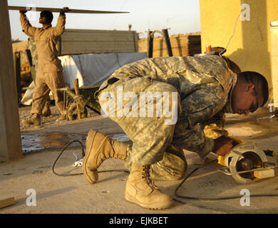 US Army Staff Sgt William Parker und Pfc. Rondy Rechirei, Ingenieure, Schnittholz, das verwendet wird, um Fenster und Türen in Shakarat, Irak, 22. März 2007 schließen. Die Soldaten sind von Alpha Company, 6. Bataillon, 9. Kavallerie-Regiment, 3rd Brigade Combat Team, 1. Kavallerie-Division und sind in Shakarat mit Othe Soldaten Durchführung von Patrouillen und Gebäude Vorposten Armee bekämpfen.   Staff Sgt Stacy L. Pearsall Stockfoto