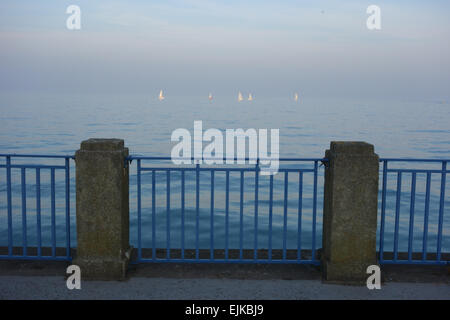 Blick auf das Meer über die Bucht auf Llandudno zahlreiche Yachten mit weißen Segeln im Blick am Abend Licht und ruhigen Meer Stockfoto