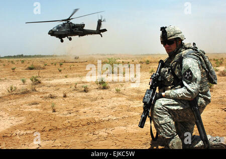 Sebastian, Florida, native Spc. Thomas Quinn, Division schnelle Reaktion Kraft Soldat für Batterie C, 1. Bataillon, 37. Feldartillerie-Regiment, 2nd Infantry Division steht Wache als ein AH - 64D Apache Helikopter nach ein abgestürztes Flugzeug Ausbildungsmission am Camp Taji, Irak startet. Quinn ist eine der vielen Soldaten, die trainieren, um schnell und kompetent stecken in einen Bereich ein abgestürztes Flugzeug, es zu sichern und seinen Piloten zu retten. US Army Spc. Nathan J. Hoskins, 1. Air Cavalry Brigade Public Affairs Stockfoto