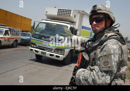 Ein US-Army Fallschirmjäger mit 2nd Battalion, 319th Airborne Field Artillery Regiment, 82. US-Luftlandedivision stoppt Verkehr während einer Verkehr Kontrollpunkt in Adhamiya, Irak, 19. Juni 2007.  Sgt. Jeffrey Alexander Stockfoto