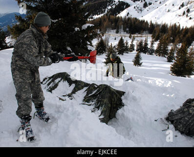 Sgt. Margarita Gutierrez der US Army in Europa 13. Military Police Company Schaufeln Schnee auf einen Unterschlupf bieten einige natürliche Isolierung vor Kälte, während eine vierwöchige USA-italienischen Winter überleben Schulung in den Dolomiten in Norditalien.  Staff Sgt David Hopkins Stockfoto