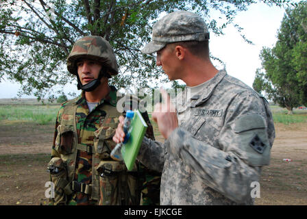 1st Lt. Cody Martin, ein Mentor aus International Company, 1. gepanzerte Brigade Combat Team, 4. US-Infanteriedivision gibt Feedback an Tadschiken Soldat auf Riot Steuerungsvorgänge Steppe Eagle 2013 im Iliskiy Training Center am 13. August.  Sgt. Lauren DeVita, Arizona Nationalgarde Public Affairs Office. Stockfoto