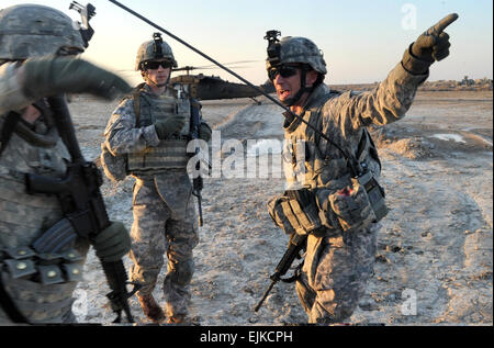 US Armee Sgt. 1. Klasse Daniel Bush mit Stabskompanie, 1. Bataillon, 68. Armor Regiment leitet US-Soldaten aus der Landezone wie ein UH-60 Black Hawk vor der irakischen Armee scharfer Munition Übung Tealeaf Insel in der Nähe von Basra, Irak, am 14. Februar 2011 landet.  Irakische Streitkräfte durchgeführt scharfer Munition Übungen, während US-Soldaten 36th Infanterie-Abteilung und 3. beraten zugewiesen und unterstützen Brigade, 4. US-Infanteriedivision vor Ort waren zu unterstützen.   Staff Sgt Michael L. Casteel, US-Armee. Stockfoto