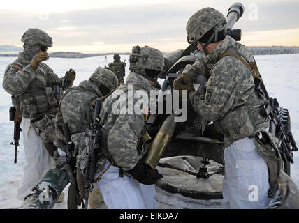 Fallschirmjäger zugewiesen A Batterie 377. Parachute Field Artillery Regiment, 2. Bataillon, 25. Infanterie-Division, Teil der US-Armee Alaska, 4th Infantry Brigade Combat Team laden eine 105mm Haubitze auf Malemute Drop-Zone bei Joint Base Elmendorf-Richardson, Alaska, 3. Dezember 2013.  Justin Connaher Stockfoto