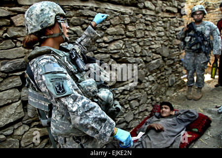 Ein Soldat der US-Armee bereitet sich auf einen verletzten afghanischen Mann in Masamute Bala in der Provinz Laghman, Afghanistan, zu behandeln, wie das Dorf ist abgesperrt und durchsucht, 25. September 2010. Der Soldat erhält das 1. Bataillon, 102. Infanterie-Regiment, 86. Brigade Combat Team.  SPC. David A. Jackson Stockfoto