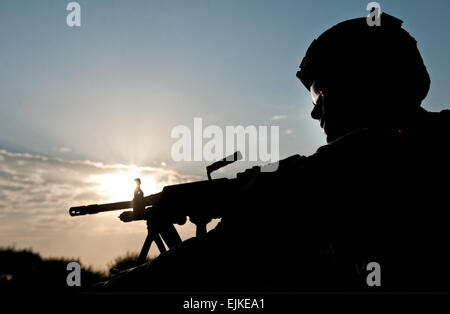 Ein US-Soldat, Bravo Truppe, 4. Geschwader, 9. Kavallerie-Regiment, 2nd Armored Brigade Combat Team, 1. Kavallerie-Division zugewiesen ist bei der Post eine Sicherheit während einer Präsenz Patrouille um Forward Operating Base Fenty in der Provinz Nangarhar, Afghanistan, 22. August 2013 Silhouette. Die Morgen-Patrouille war die Sicherheitsüberprüfung von der Basis Umfang und Bereich Einwohner einbringen. US Army National Guard Foto von Sgt. Margaret Taylor Stockfoto