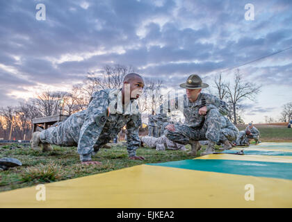 Staff Sgt Adam Zimmerman beobachtet Spc. Tony Brown, 3. chemische Brigade, da er tagsüber Liegestütze, die zwei wird in Fort Leonard Wood, Mo. Brown 1-5 April 2013 statt 2013 besten Krieger Wettbewerb konkurriert vollendet, die Installation nächste Soldat des Jahres zu sein.  Michael Curtis Stockfoto