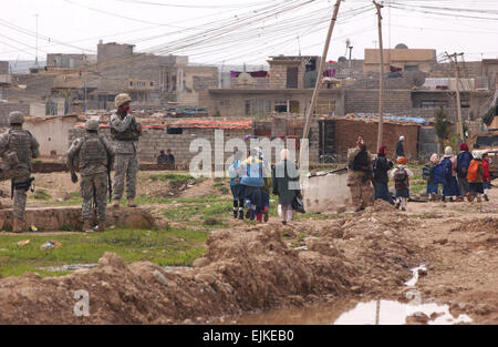 Irakische Kinder Heimweg von der Schule als irakische Polizisten und Soldaten der US Armee von Delta Company, 2. Bataillon, 7. Kavallerie-Regiment, 4th Brigade Combat Team, 1. Kavallerie-Division Fort Bliss, Texas, führen eine Patrouille in ihrer Nachbarn in Mosul, Irak, 19. März 2007.  Senior Airman Vanessa Valentine Stockfoto