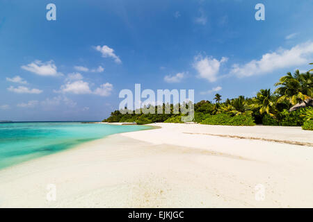 Ein Blick auf den Strand auf Makunudu Island auf den Malediven mit einem Katamaran in der Ferne Stockfoto