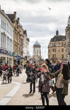 Oxford, UK. 27. März 2015. A Street-Artist bläst Luftblasen, die von Passanten auf Cornmarket Street, Oxford, Kredit genossen werden: CBCK-Christine/Alamy Live News Stockfoto