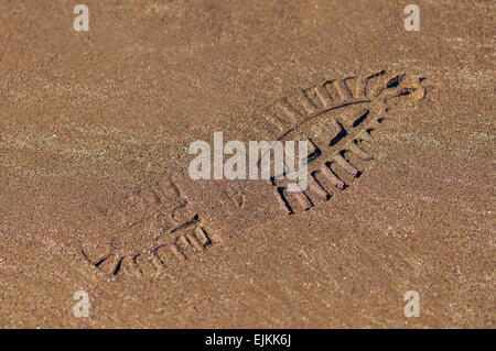 Schuh-Fußabdruck auf nassen Sand Textur Stockfoto