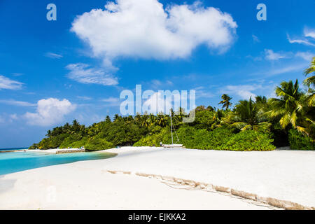 Ein Blick auf den Strand auf Makunudu Island auf den Malediven mit einem Katamaran in der Ferne Stockfoto