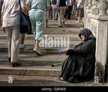 Venedig, Provinz Venedig, Italien. 6. Oktober 2004. Eine ältere bedürftige Frau auf den Stufen des Ponte della Paglia in Venedig bittet um Almosen als Touristen an ihr vorbei. © Arnold Drapkin/ZUMA Draht/Alamy Live-Nachrichten Stockfoto