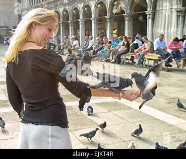 Venedig, Provinz Venedig, Italien. 6. Oktober 2004. Eine attraktive junge Frau Touristen speist die allgegenwärtigen Tauben in der Piazza San Marco. Venedig gehört zu den beliebtesten internationalen Reisezielen. © Arnold Drapkin/ZUMA Draht/Alamy Live-Nachrichten Stockfoto