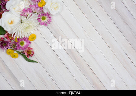 Hohen Winkel Schuss einen Blumenstrauß in der oberen linken Ecke des Rahmens. Bunte Frühlingsblumen Zeit auf einem rustikalen weißen Holz Stockfoto