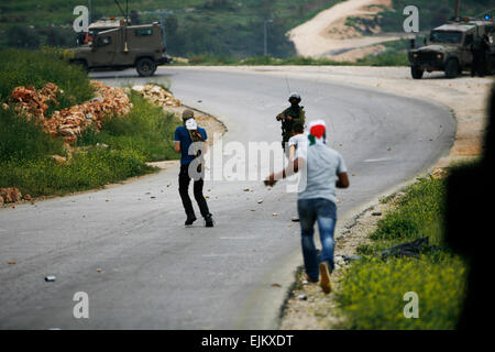 Palästina. 28. März 2015. Ein palästinensischen Demonstranten bereitet sich auf einen Stein gegen israelische Truppen während einer Protestaktion anlässlich Tag des Bodens, in der West Bank Dorf Nabi Saleh in der Nähe von Ramallah, Samstag, 28. März 2015 zu schleudern. Tag des Bodens erinnert Unruhen am 30. März 1976, wenn sechs israelische Araber von Sicherheitsbeamten beim Protest gegen die israelische Regierung Enteignungen Landpolitik getötet wurden. Bildnachweis: Muhesen Amren/Pacific Press/Alamy Live-Nachrichten Stockfoto