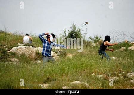 Palästina. 28. März 2015. Ein palästinensischen Demonstranten bereitet sich auf einen Stein gegen israelische Truppen während einer Protestaktion anlässlich Tag des Bodens, in der West Bank Dorf Nabi Saleh in der Nähe von Ramallah, Samstag, 28. März 2015 zu schleudern. Tag des Bodens erinnert Unruhen am 30. März 1976, wenn sechs israelische Araber von Sicherheitsbeamten beim Protest gegen die israelische Regierung Enteignungen Landpolitik getötet wurden. Bildnachweis: Muhesen Amren/Pacific Press/Alamy Live-Nachrichten Stockfoto