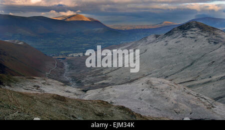 Berglandschaft des Lake District von Grisdale Pike entlang Coledale Zurück in Richtung Blencathra bedeckt mit Frost und einem entfernten Höhepunkt beleuchtet von der Abendsonne Stockfoto