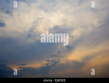 Sonnenuntergang verbirgt sich hinter den Wolken bei Starkwind Stockfoto