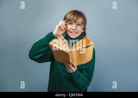 Europäisch anmutende junge mit Brille hält ein Buch in seinen Händen-sm Stockfoto