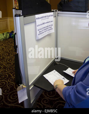 weibliche Wähler gießen ihre Stimme durch die Markierung der Wahlzettel mit Kreuz im Wahllokal Stockfoto