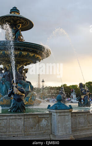 Die Fontaine des Fleuves bei Sonnenuntergang in der Place De La Concorde, Paris, Frankreich; der Eiffelturm ist in der Ferne sichtbar. Stockfoto