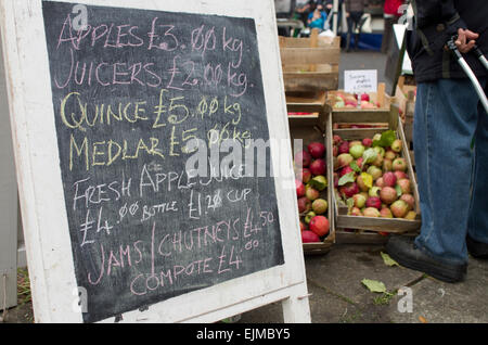 Bauernmarkt in Stoke Newington, London, Apple Verkäufer Tafel Zeichen mit Äpfeln im Hintergrund Stockfoto