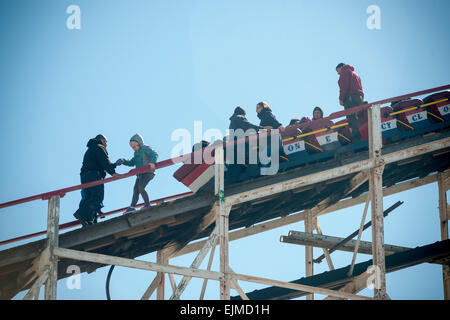 Coney Island, USA. 29. März 2015. Nachdem es auf seinen ersten Lauf der Saison Sommer 2015 auf Donnerstag, 29. März 2012 stecken Unterstützung von Arbeitnehmern Nervenkitzel auf der Luna Park Coney Island Cyclone-Achterbahn. Der Zug hielt kurz vor den ersten Tropfen als Sicherheitsmerkmal trat als Förderer Gürtel verwendet, um die Achterbahn rutschte von der Strecke zu treiben. Die ersten Fahrer mussten eskortiert hinunter das Wahrzeichen Holzachterbahn nach stecken für ca. 5 Minuten.  Es gab keine Verletzten. Bildnachweis: Richard Levine/Alamy Live-Nachrichten Stockfoto