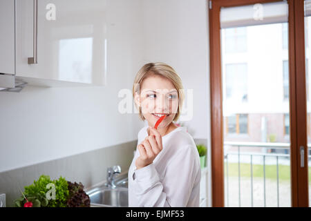 Frau zeigt Scheiben Paprika Stockfoto