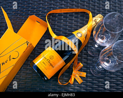 Flasche Veuve Clicquot Luxus Champagner Geschenkbox und Gläser auf sonnigen outdoor alfresco Wicker Tischfläche Stockfoto