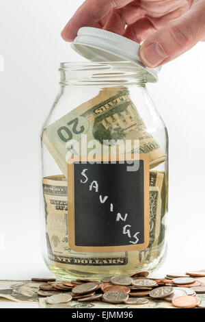 Hand öffnen Deckel aus Glas jar auf weißem Hintergrund mit schwarzer Kreide Label und für Einsparungen US-Dollarnoten verwendet Stockfoto