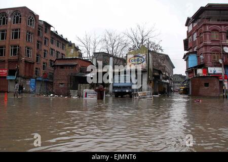 Srinagar, Kaschmir. 29. März 2015. Einer zentralen indischen Reservesoldat Polizei (CRPF) überquert eine durchnässtes Straße im kommerziellen Zentrum von Srinagar im Sommer, die Hauptstadt des indischen Kaschmir auf März verabreicht 29,2015. Das Tal hat erlebt schwere Regenfälle seit Samstag, führt zu einem frischen Fluten Panik und plötzlichen Anstieg der Wasserpegel in den Flüssen, Bächen und Rinnsalen über Kaschmir. Bildnachweis: NISARGMEDIA/Alamy Live-Nachrichten Stockfoto