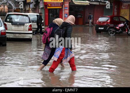 Srinagar, Kaschmir. 29. März 2015. Einer zentralen indischen Reservesoldat Polizei (CRPF) überquert eine durchnässtes Straße im kommerziellen Zentrum von Srinagar im Sommer, die Hauptstadt des indischen Kaschmir auf März verabreicht 29,2015. Das Tal hat erlebt schwere Regenfälle seit Samstag, führt zu einem frischen Fluten Panik und plötzlichen Anstieg der Wasserpegel in den Flüssen, Bächen und Rinnsalen über Kaschmir. Bildnachweis: NISARGMEDIA/Alamy Live-Nachrichten Stockfoto