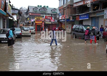 Srinagar, Kaschmir. 29. März 2015. Einer zentralen indischen Reservesoldat Polizei (CRPF) überquert eine durchnässtes Straße im kommerziellen Zentrum von Srinagar im Sommer, die Hauptstadt des indischen Kaschmir auf März verabreicht 29,2015. Das Tal hat erlebt schwere Regenfälle seit Samstag, führt zu einem frischen Fluten Panik und plötzlichen Anstieg der Wasserpegel in den Flüssen, Bächen und Rinnsalen über Kaschmir. Bildnachweis: NISARGMEDIA/Alamy Live-Nachrichten Stockfoto