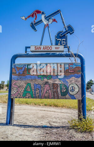 Willkommen bei San Ardo Zeichen mit einer Skulptur von einem Öl-Bohr-Bohrschwengels mit einem Cowboy mit Sporen auf der Ölbohrinsel Reiten. Stockfoto