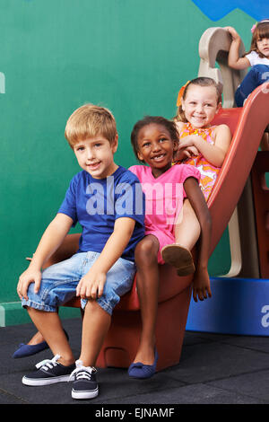 Glückliche Gruppe von Kindern beim Spielen auf Folie in der Vorschule Stockfoto