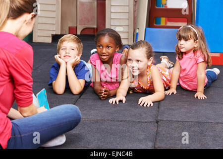 Kindergärtnerin Geschichte Buch, Gruppe von Kindern im kindergarten Stockfoto