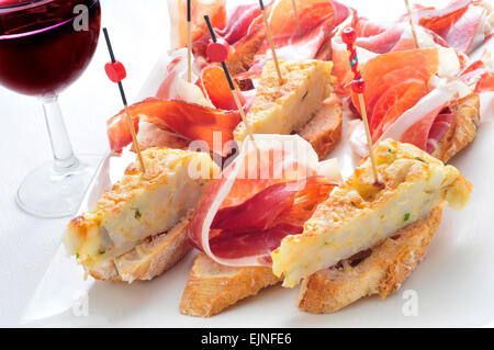Nahaufnahme einer Platte mit typisch spanischen Pincho de Tortilla und Pincho de Jamon, spanische Omelette und Serrano-Schinken, serviert auf b Stockfoto