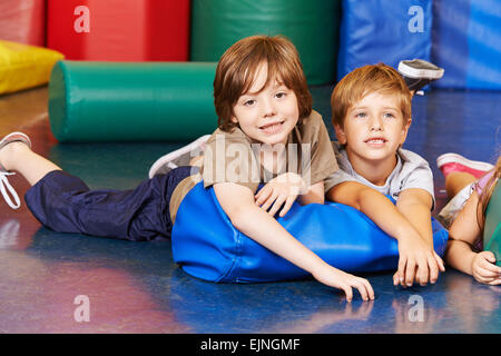 Zwei jungen in der Turnhalle, die Verlegung auf einem Kissen in der Grundschule Stockfoto