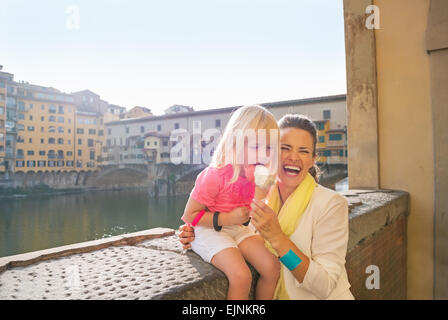 Glückliche Mutter und Babymädchen Essen ein Eis in der Nähe von Ponte Vecchio in Florenz, Italien Stockfoto