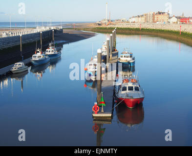 Boote vertäut am Yachthafen in Kimnel Bay, Rhyl in Wales die Drachenbrücke mit Rhyl im Hintergrund entnommen. Stockfoto