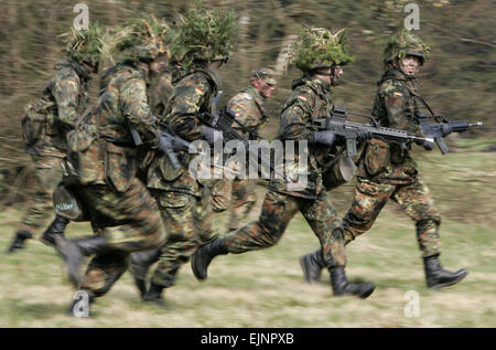 Schwarzenborn, Deutschland. 14. April 2005. (Dpa-Datei) - eine Gruppe von Wehrpflichtigen der gepanzerten Infanterie-Division der Bundeswehr, in Camouflage gekleidet und bewaffnet mit einem G36 Gewehr, laufen über ein Feld in ein Feld Übung im Rahmen der militärischen Grundausbildung in der Knuell-Kaserne in Schwarzenborn, Deutschland, 14. April 2005. © Dpa/Alamy Live-Nachrichten Stockfoto